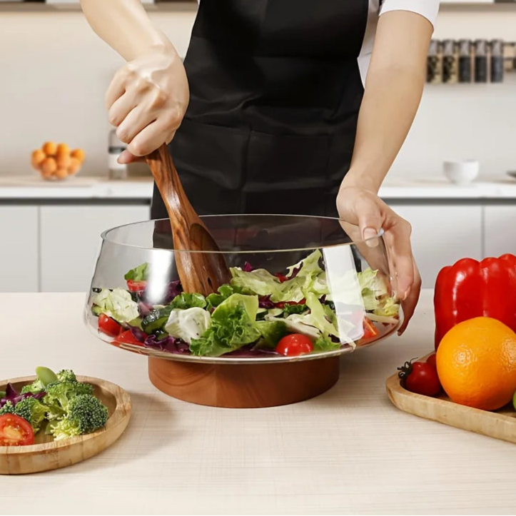 Salad bowl made of glass with wooden base and cutlery
