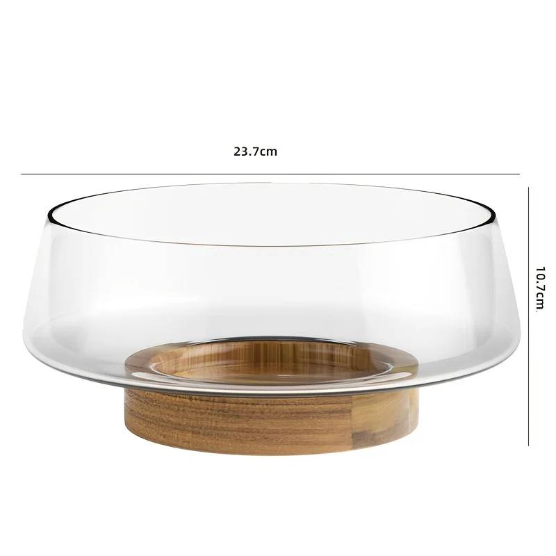 Salad bowl made of glass with wooden base and cutlery