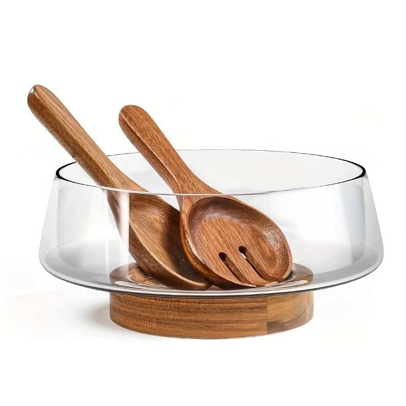 Salad bowl made of glass with wooden base and cutlery