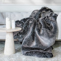 Graue Kuscheldecke aus Kunstfell auf dem Bett